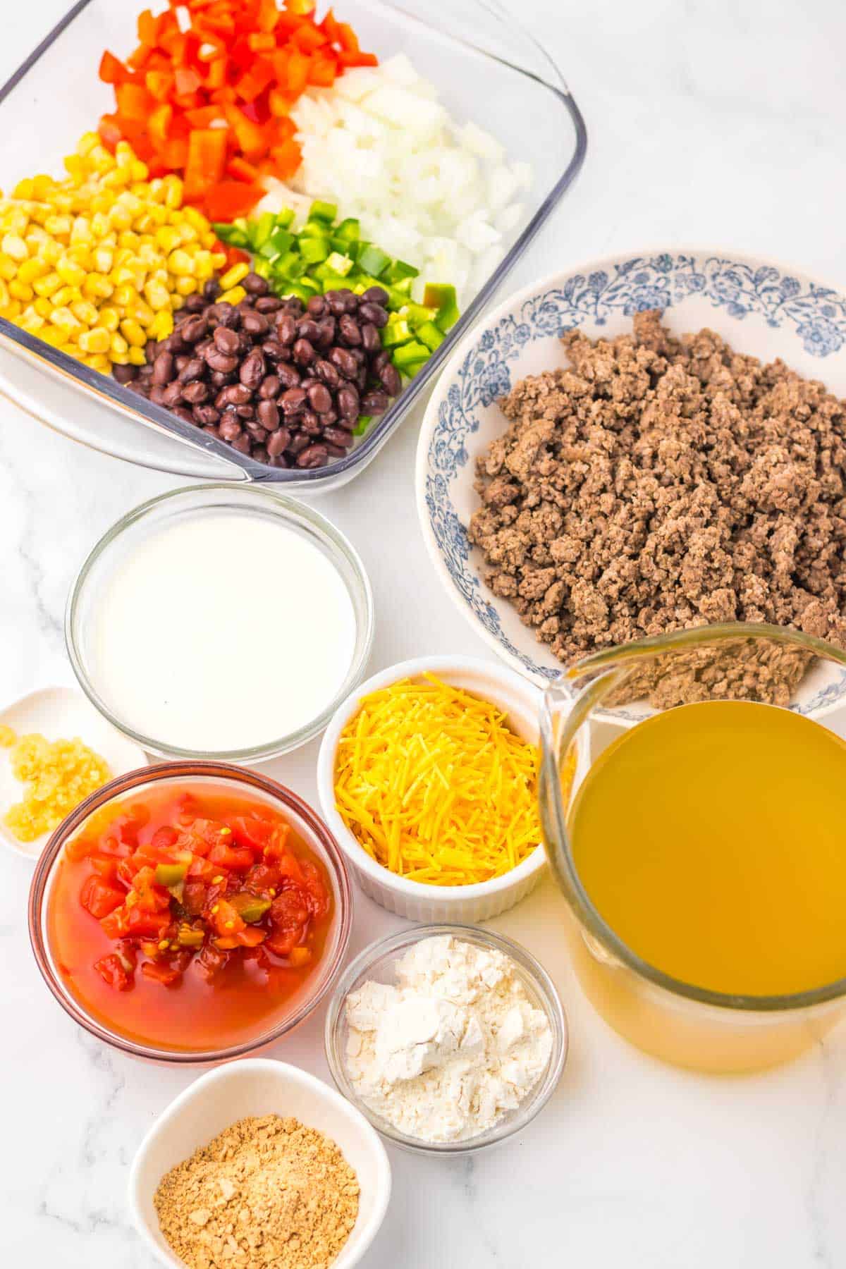 Ingredients for Nacho Soup include ground beef, black beans, corn, diced veggies, cheese, broth, and seasonings&mdash;a perfect recipe to make in your slow cooker.