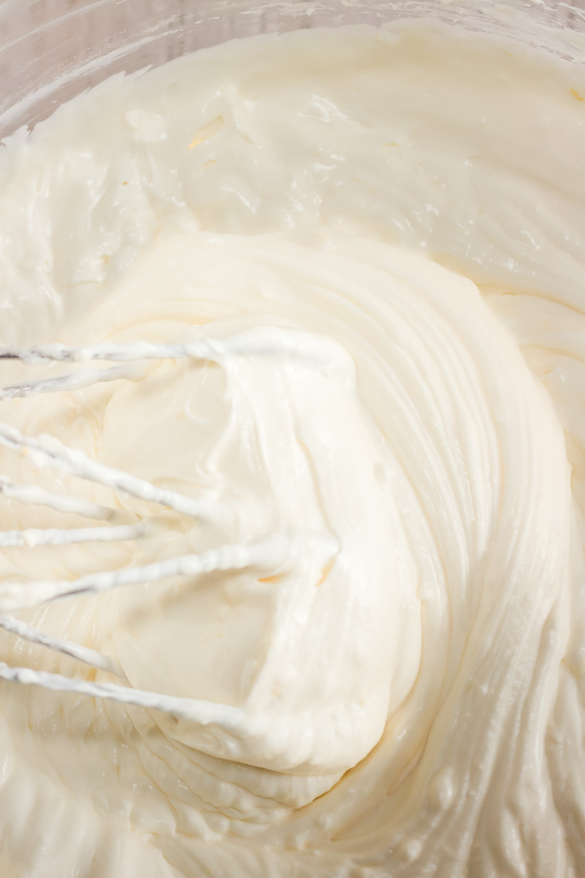 Thick, creamy white mixture being whisked in a bowl—perfect for starting a Raspberry Lemon Cheesecake recipe or preparing an Instant Pot dessert.