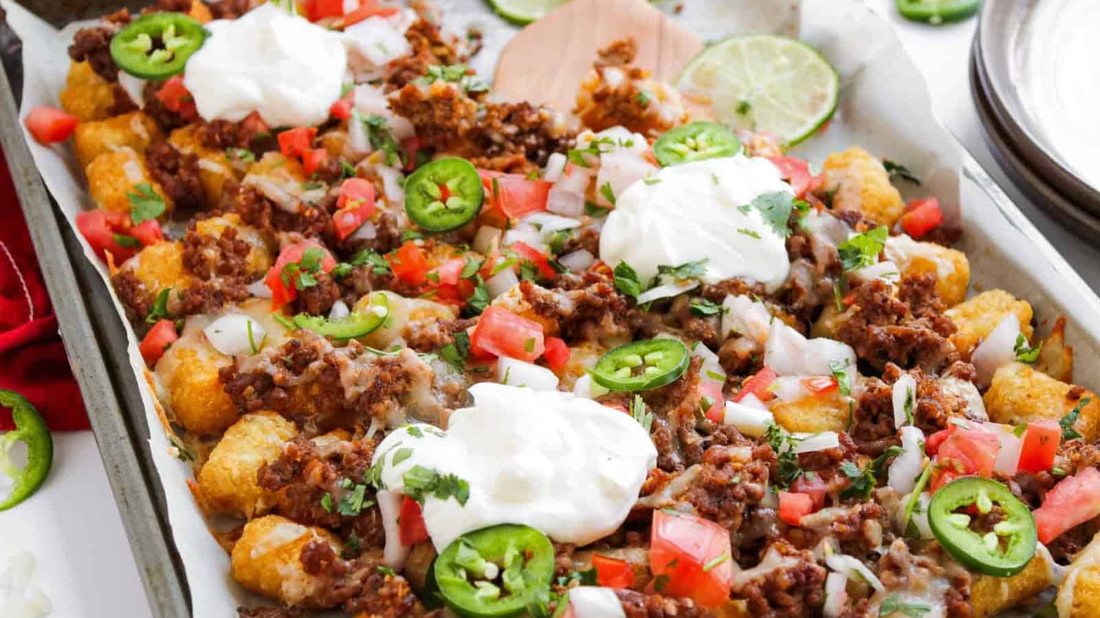 Tater tots topped with ground beef, tomatoes, onions, jalapeños, melted cheese, and dollops of sour cream.