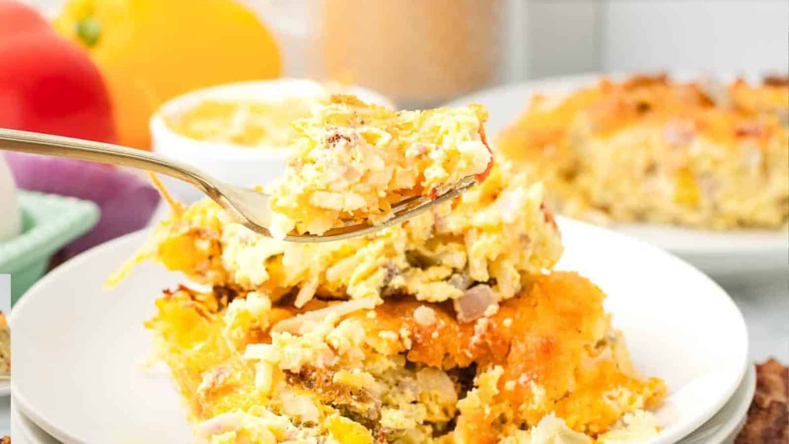 A wooden spoon holds a cheesy, golden-brown casserole with visible chunks of vegetables and melted cheese.