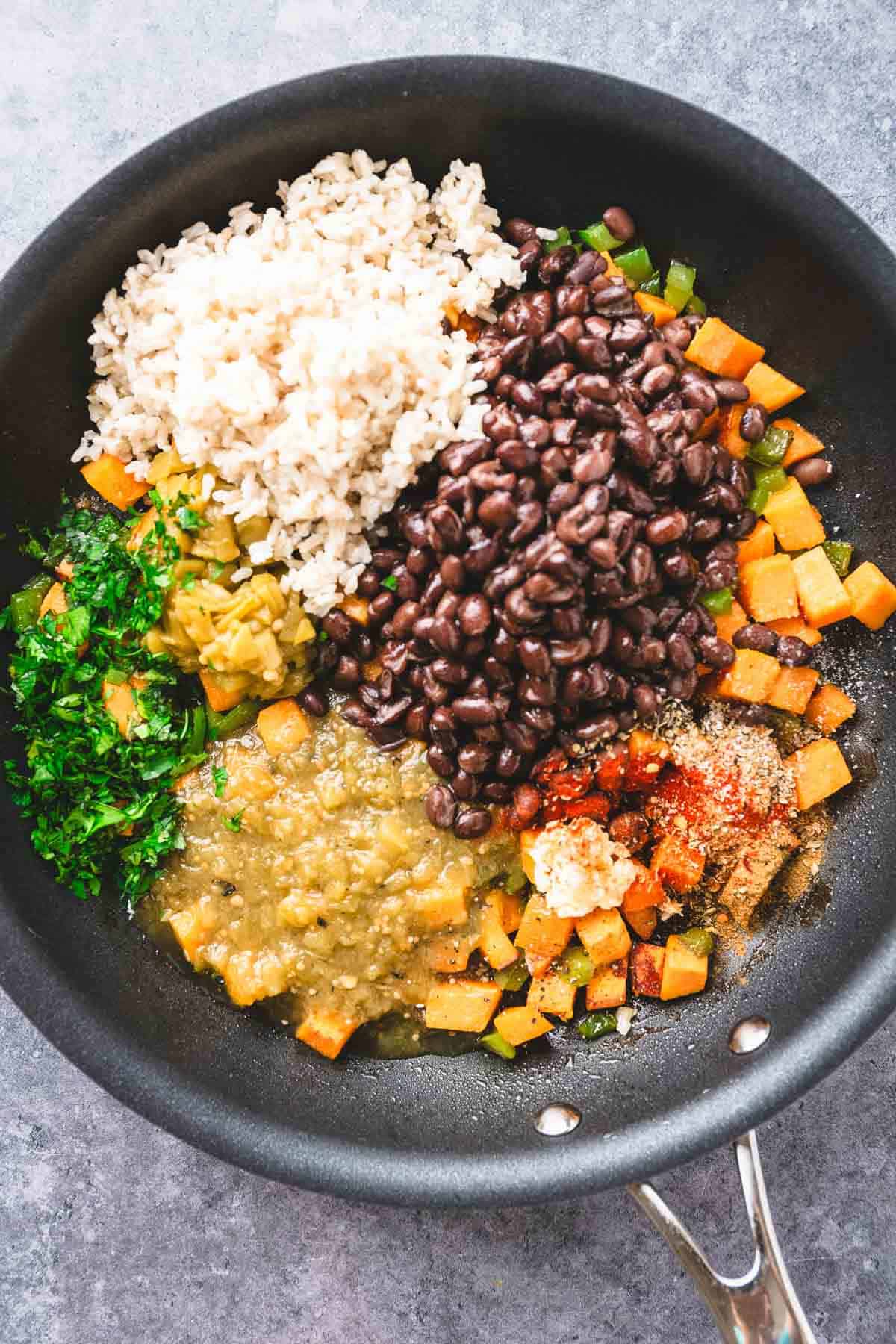 A Southwest sweet potato rice skillet with black beans, diced sweet potatoes, green salsa, spices, herbs, and green chiles.