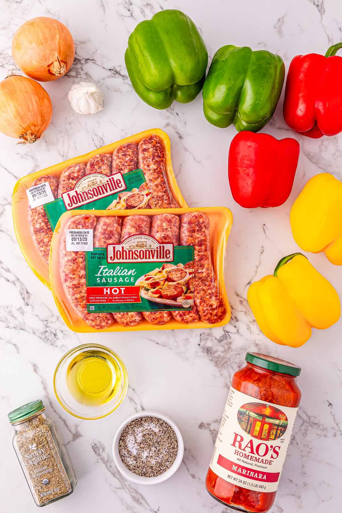 Two packs of Italian sausage, bell peppers, onions, garlic, oil, spices, and a jar of marinara sauce on a counter.