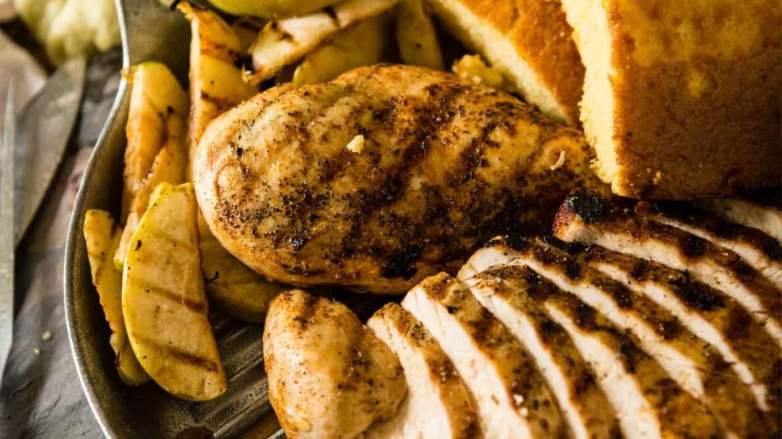 BBQ chicken breasts topped with grilled Granny Smith apple slices showing char marks and caramelized edges.