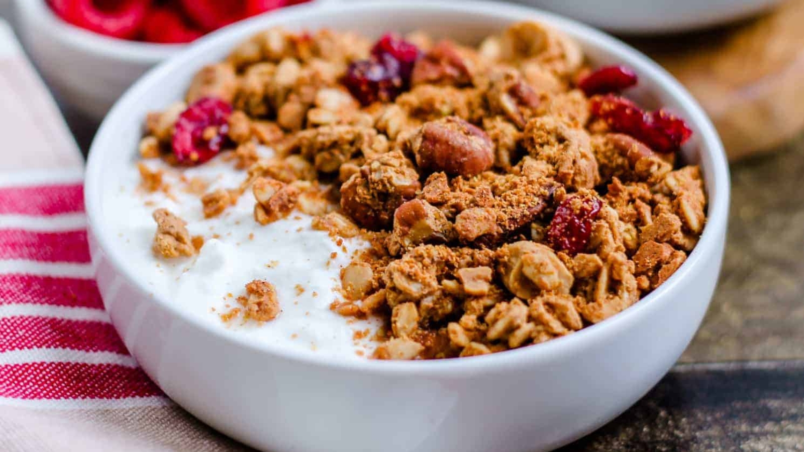 A bowl of protein granola on top of yogurt and garnished with fresh berries.