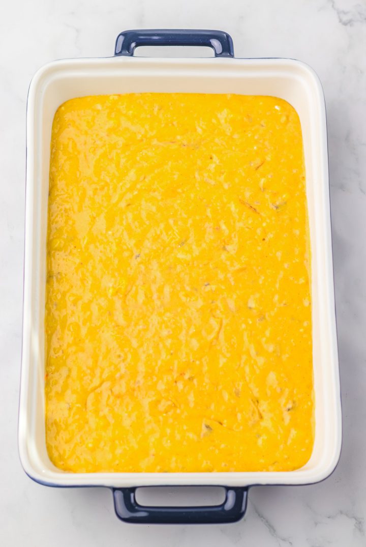 Rectangular dish filled with a smooth, bright yellow-orange mixture, ready to be baked&mdash;perfect as a base for a delicious Hummingbird Poke Cake.