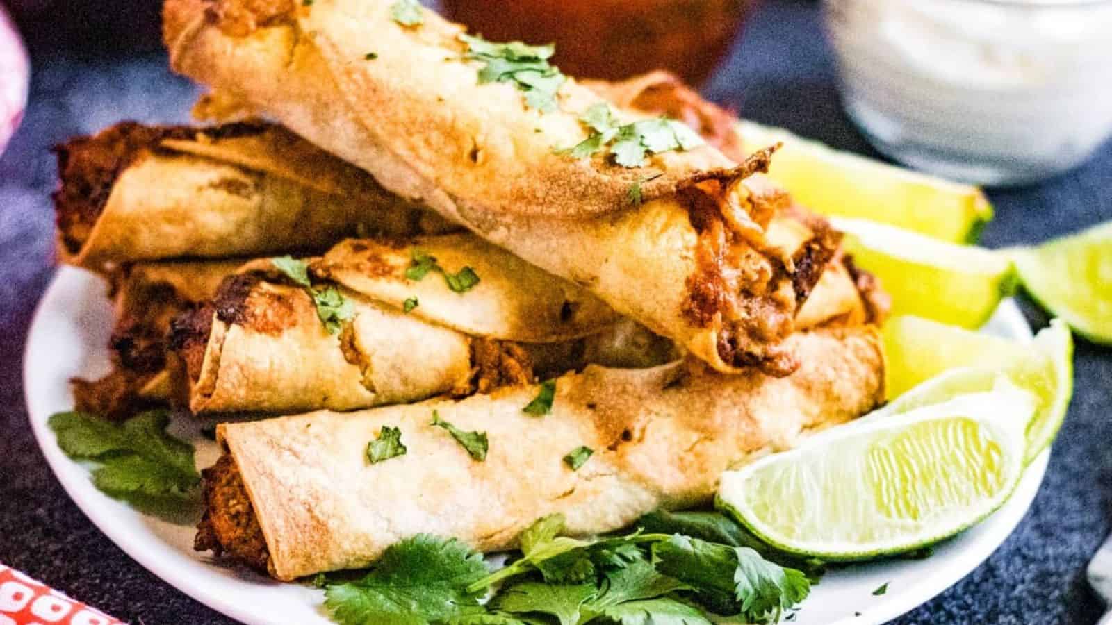 Stacked taquitos on a plate.