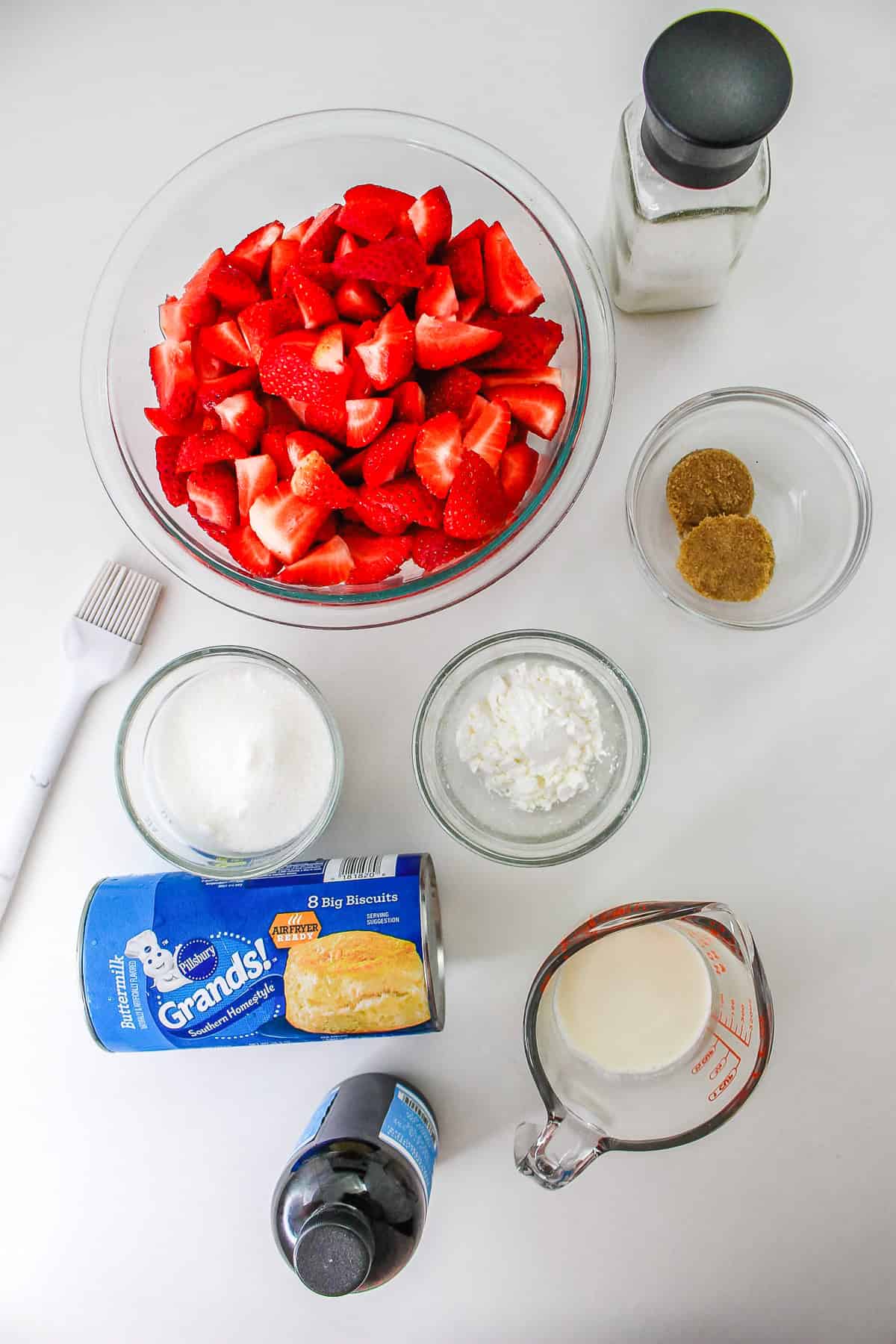 Sliced strawberries, sugar, brown sugar, cornstarch, milk, biscuits, vanilla, salt, and a pastry brush come together to create a delicious Strawberry Shortcake Casserole.