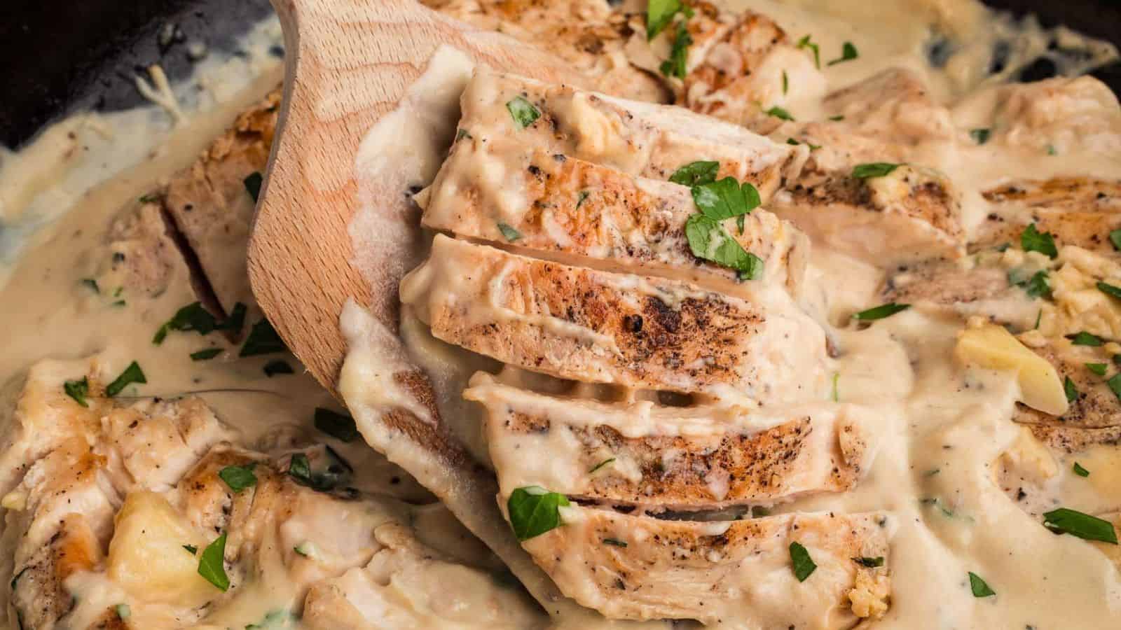 Creamy garlic chicken with golden seared pieces coated in thick sauce in a skillet.
