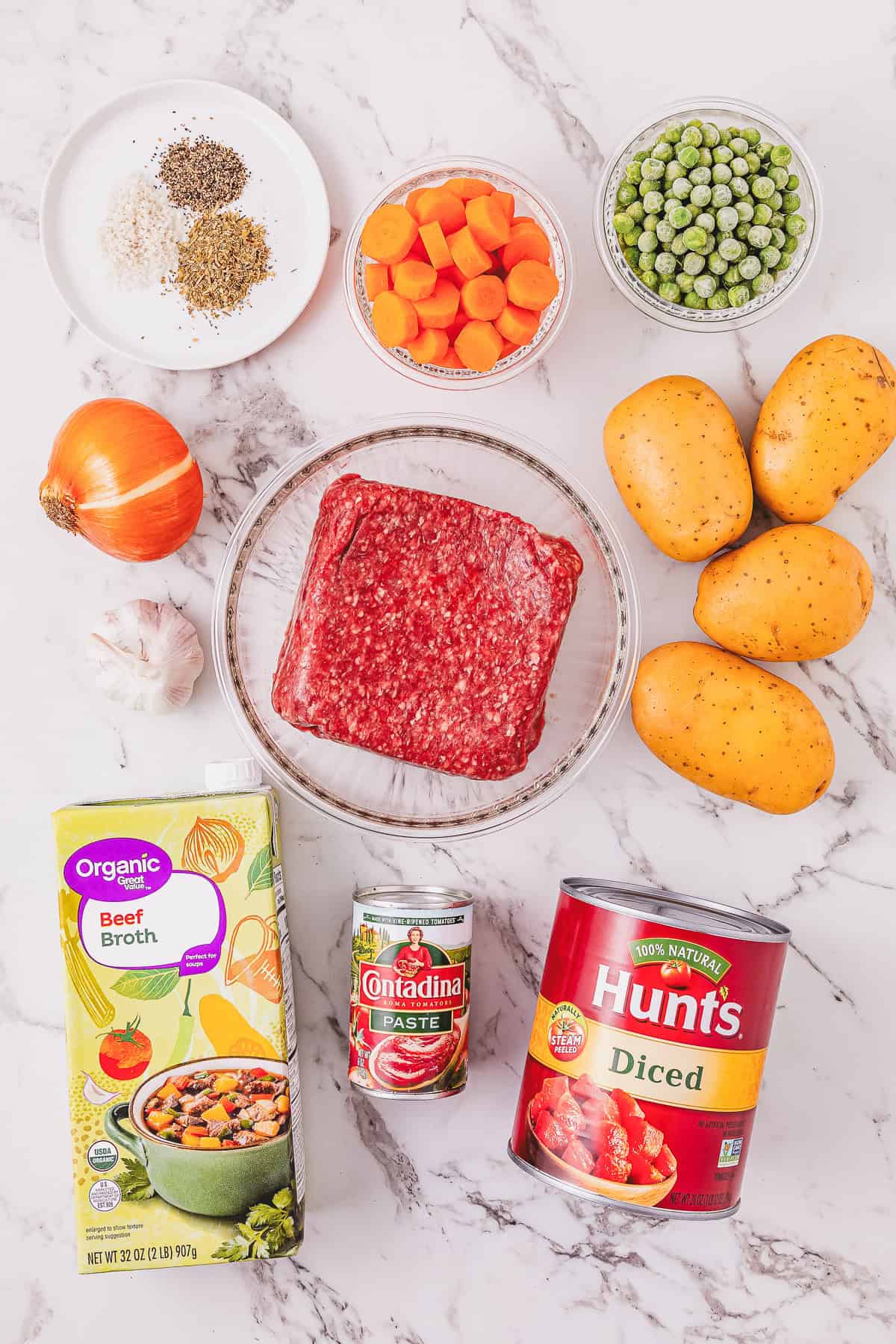 Ground beef, carrots, peas, potatoes, onion, garlic, spices, beef broth, tomato paste, and diced tomatoes.