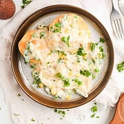 Chicken pot pie biscuits topped with creamy vegetable gravy on a plate.