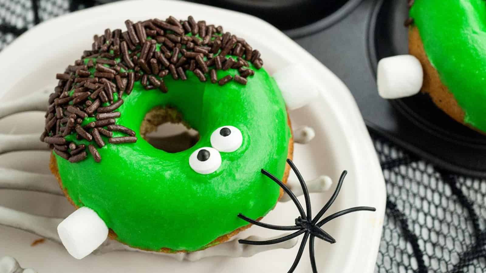 Halloween donut decorated as Frankenstein with green icing and candy details.