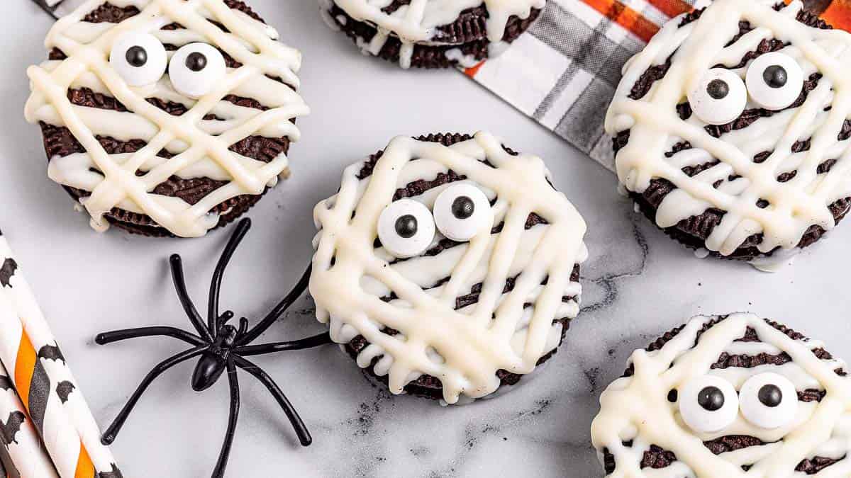 Oreo mummy cookies decorated with white icing and candy eyes.