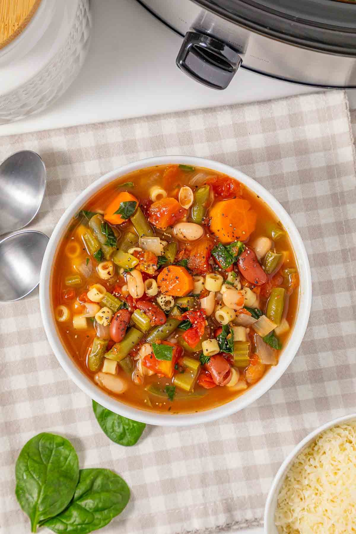 A bowl of slow cooker minestrone soup with vegetables, beans, and pasta.