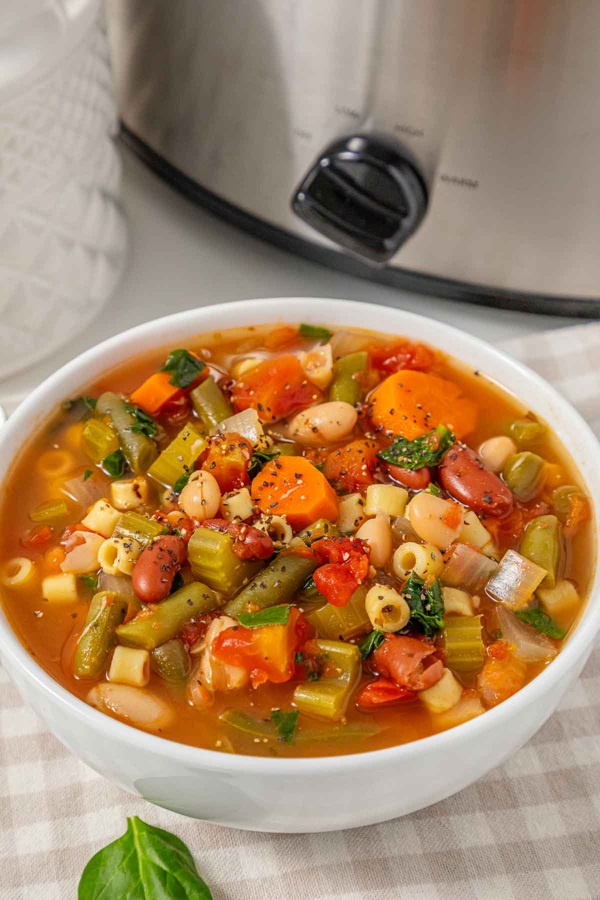 A bowl of slow cooker vegetable minestrone soup with pasta and beans.