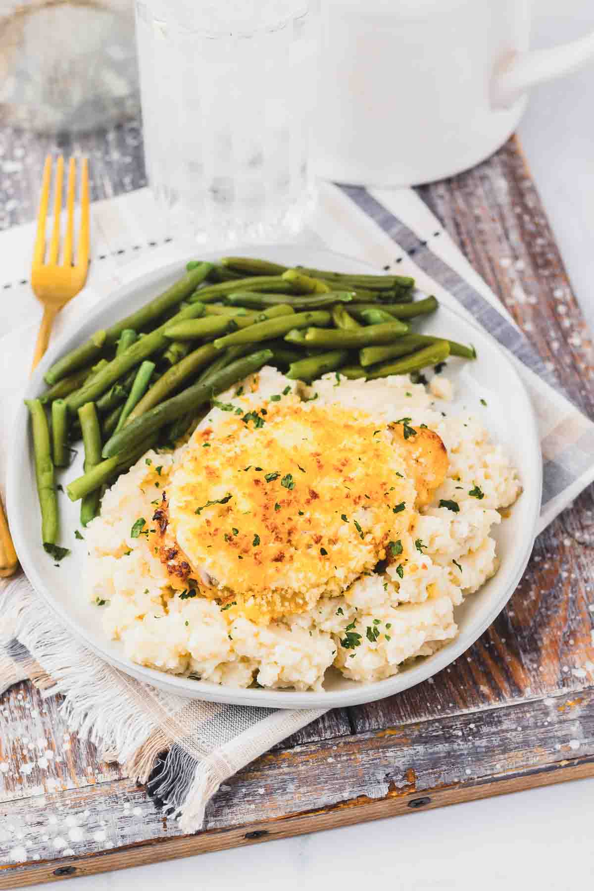 Copycat Longhorn Parmesan crusted chicken served with mashed potatoes and green beans.