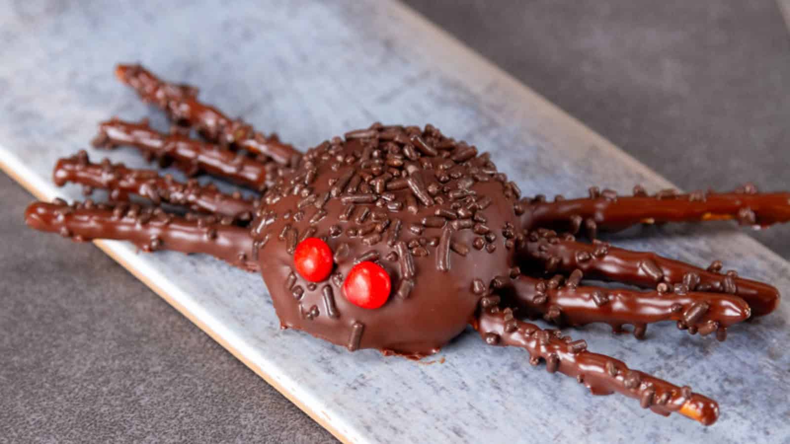 Chocolate tarantula-shaped Halloween cookies decorated with candy eyes and chocolate legs.